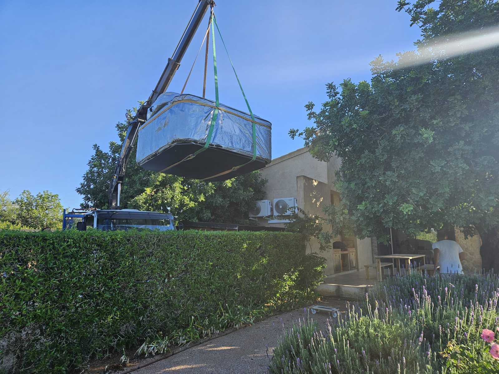 The wrapped whirlpool craned in over the hedge at Casa Viduleto