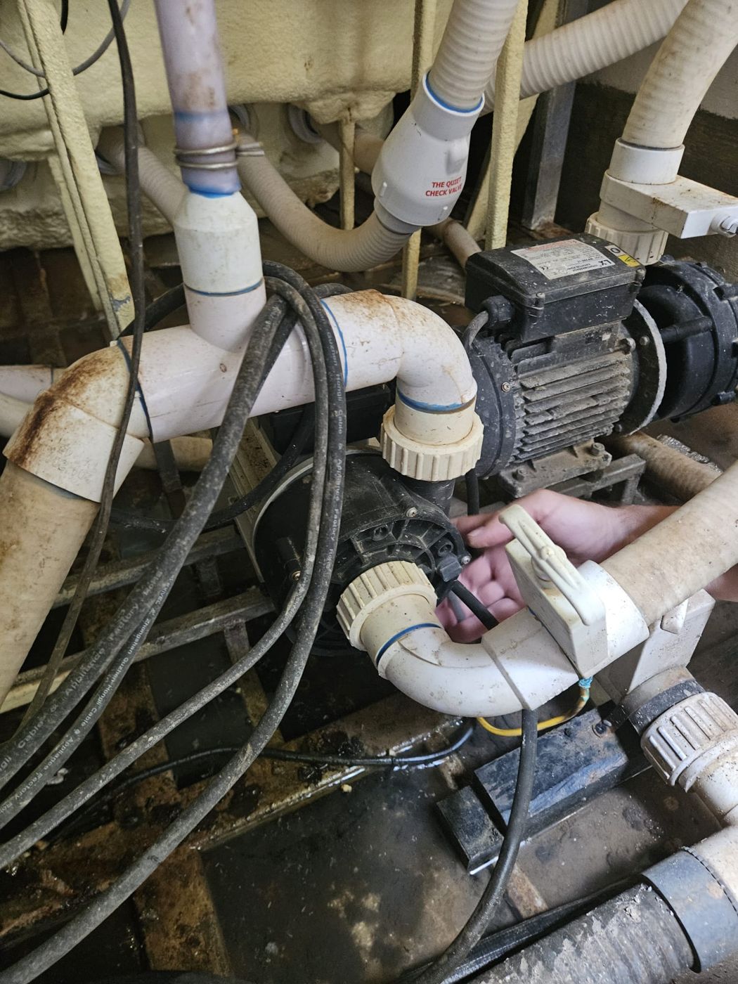 The worn circulation pump being disconnected from its unions in the technical bay