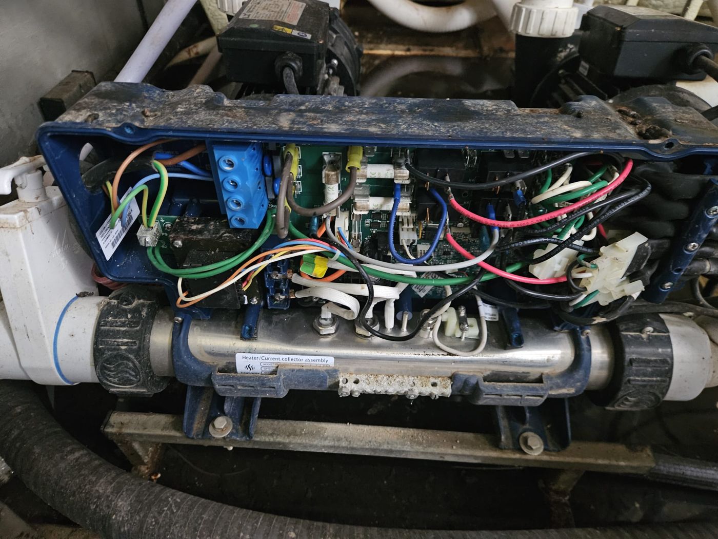 Technical bay under the deck with heater, control pack wiring and pipework before the repair