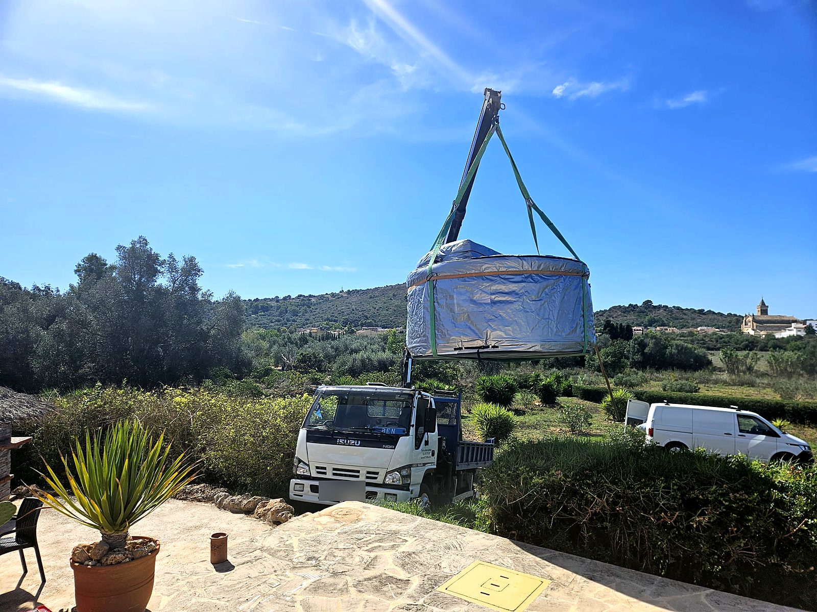 Kran hebt den verpackten Whirlpool auf die Terrasse in Son Carrió