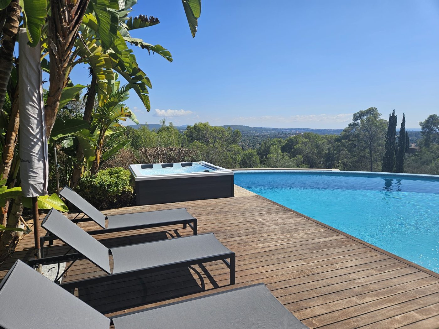 The finished Nizza II whirlpool beside the pool with sun loungers, at the Bunyola finca