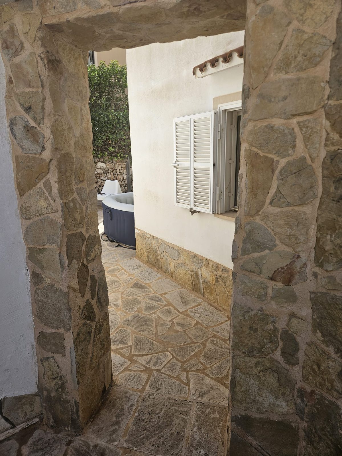 Narrow stone archway leading into the walled courtyard in Cala Santany&iacute;