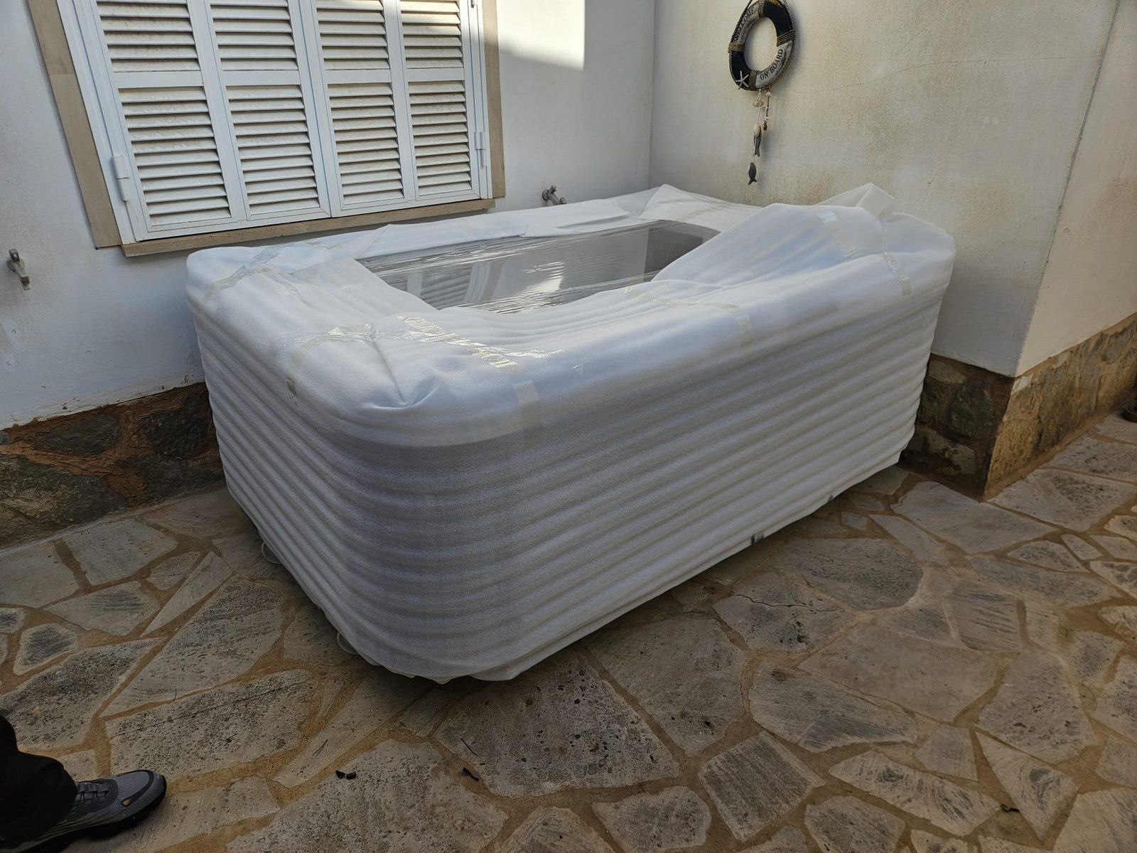 The wrapped whirlpool lowered safely into the courtyard